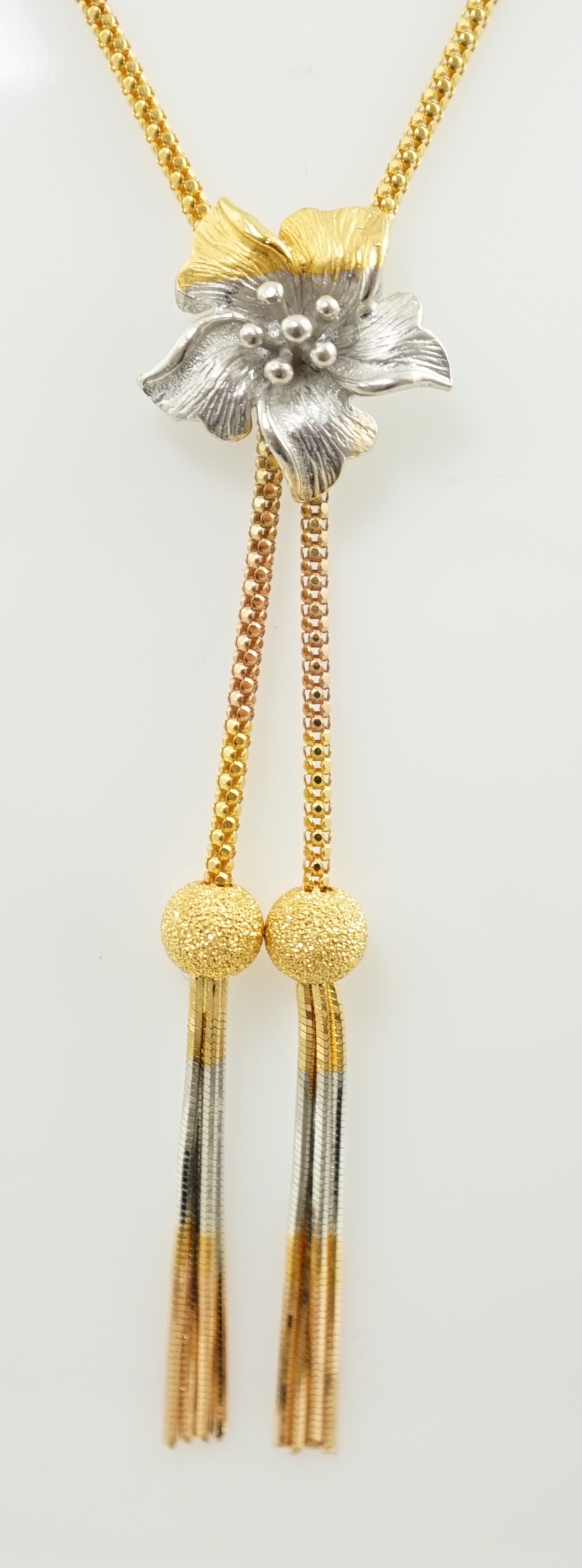 A recent Middle Eastern three colour 22k gold tassel drop necklace and pair of matching drop earrings